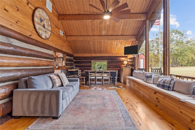 living room with log walls, wood-type flooring, ceiling fan, and beamed ceiling