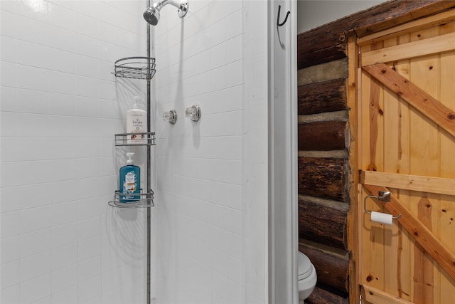 bathroom with tiled shower and toilet