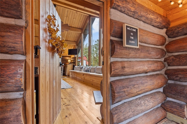 staircase featuring beam ceiling, wood-type flooring, wood ceiling, and log walls