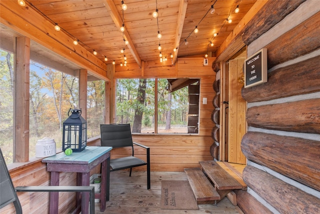 sunroom featuring beam ceiling, wooden ceiling, and track lighting