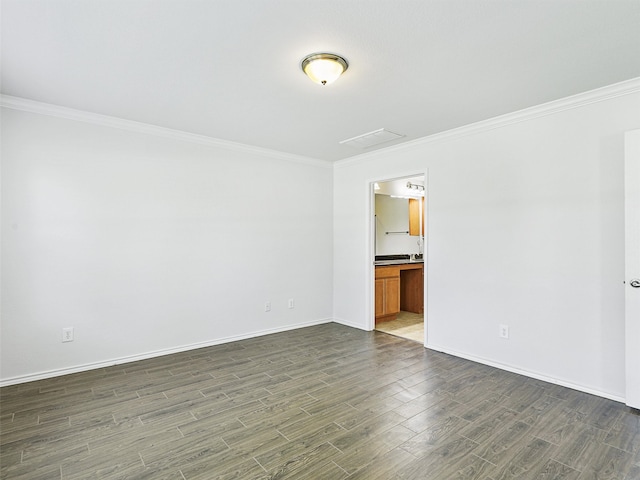 spare room featuring dark hardwood / wood-style flooring and crown molding