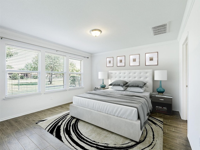 bedroom with dark wood-type flooring and crown molding