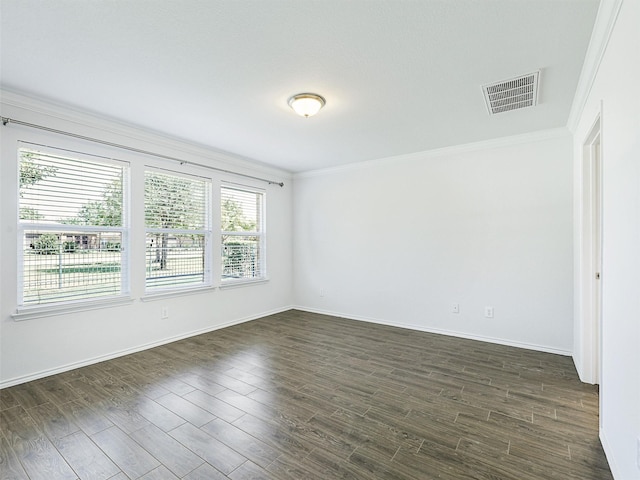 spare room featuring ornamental molding and dark hardwood / wood-style floors