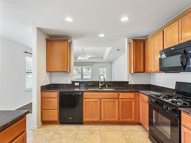 kitchen featuring sink, dark stone countertops, a chandelier, light tile patterned floors, and black appliances