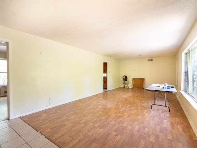 unfurnished room with a textured ceiling and light hardwood / wood-style flooring