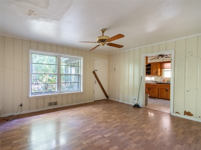 unfurnished living room featuring light hardwood / wood-style flooring, a textured ceiling, and ceiling fan