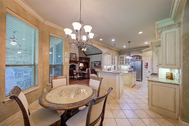 tiled dining space featuring a chandelier, a fireplace, and crown molding