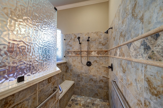 bathroom with ornamental molding and tiled shower