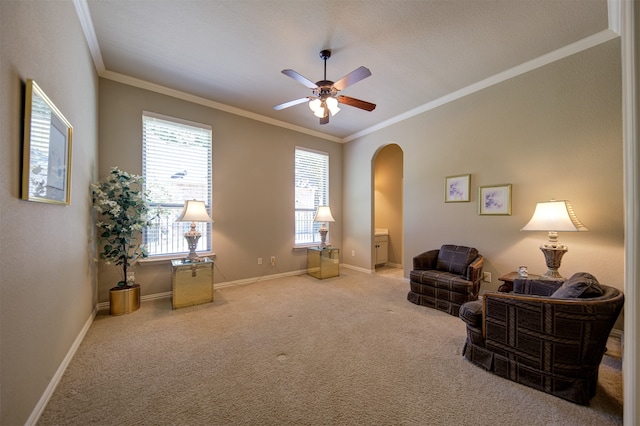 sitting room with ornamental molding, carpet, and ceiling fan