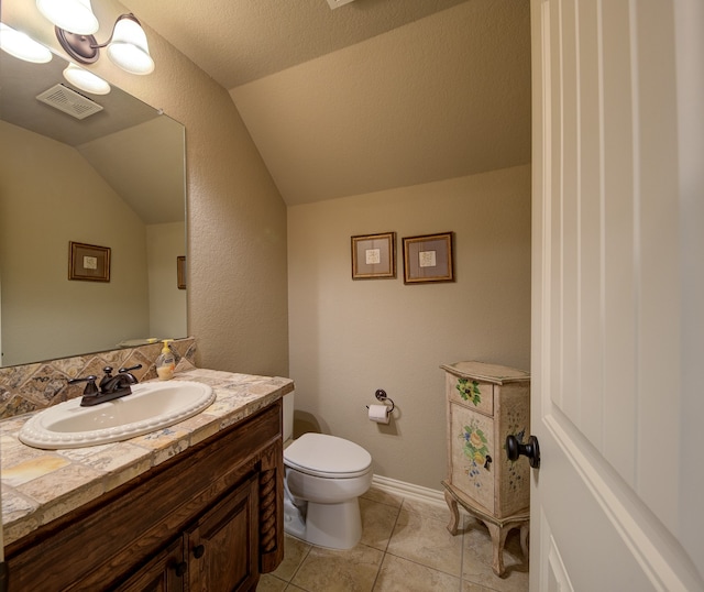 bathroom featuring vanity, lofted ceiling, a textured ceiling, tile patterned floors, and toilet