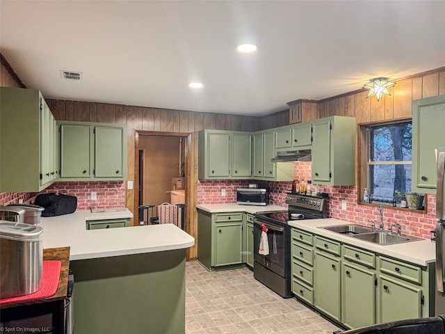 kitchen featuring green cabinetry, sink, wood walls, and black range with electric cooktop