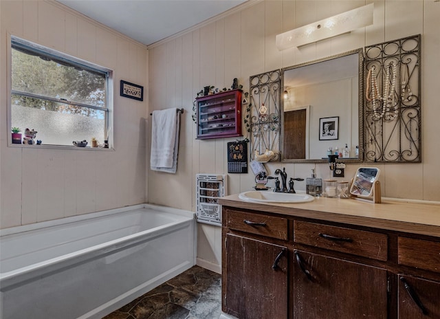 bathroom with vanity, a bath, and crown molding