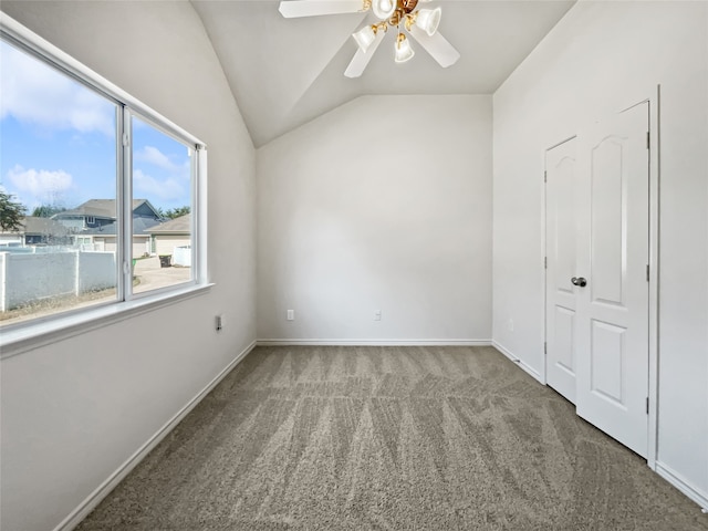 carpeted empty room with vaulted ceiling and ceiling fan