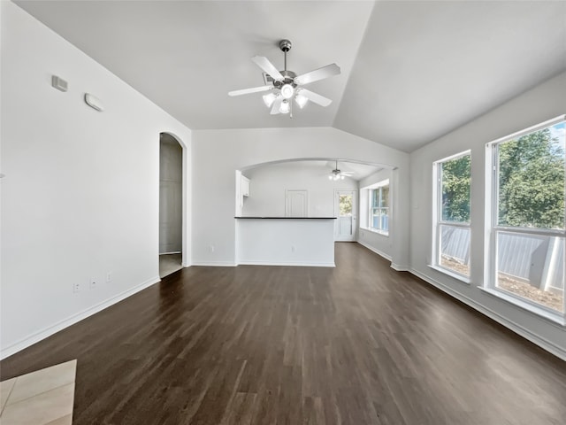 unfurnished living room featuring lofted ceiling, dark wood-type flooring, and ceiling fan