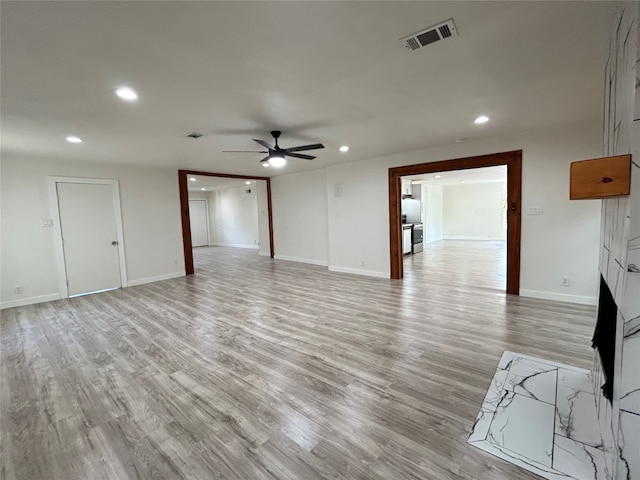 unfurnished living room featuring ceiling fan and light hardwood / wood-style floors