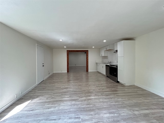 unfurnished living room featuring light hardwood / wood-style flooring and sink