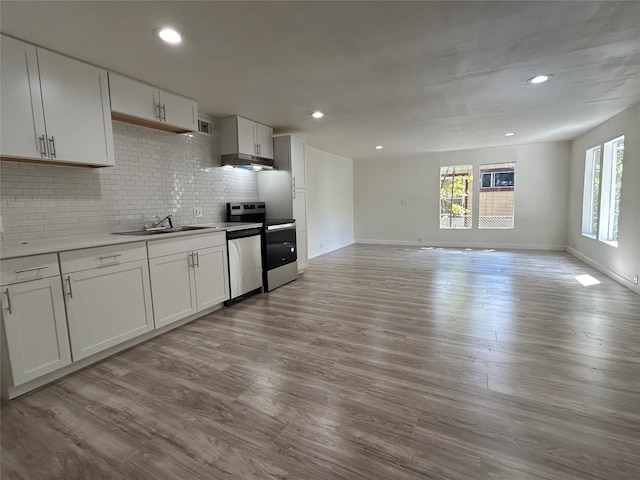 kitchen featuring sink, white cabinetry, stainless steel appliances, light hardwood / wood-style floors, and decorative backsplash