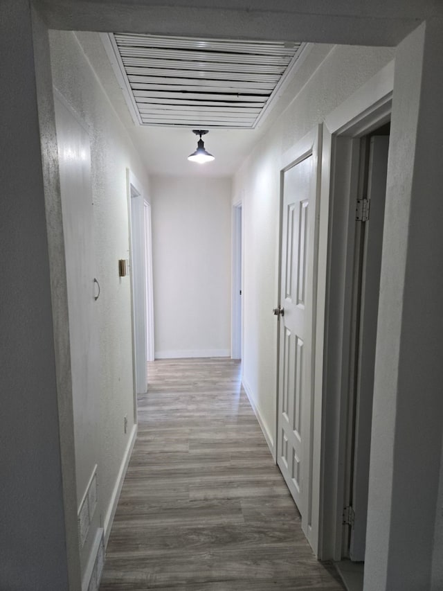 hallway with hardwood / wood-style floors