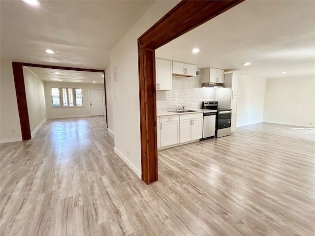 kitchen with appliances with stainless steel finishes, white cabinetry, sink, and light hardwood / wood-style floors