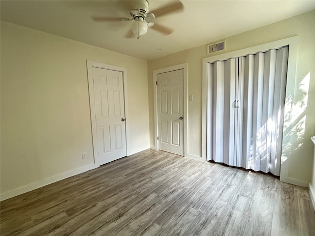 unfurnished bedroom featuring hardwood / wood-style floors and ceiling fan