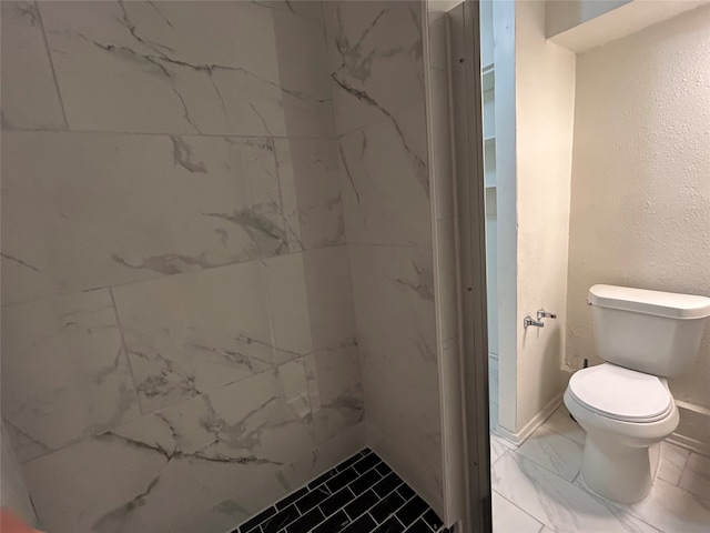 bathroom with toilet and tiled shower