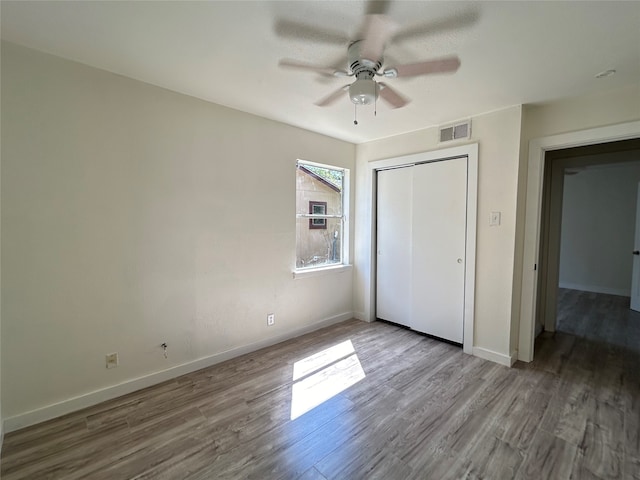 unfurnished bedroom featuring ceiling fan, light wood-type flooring, and a closet