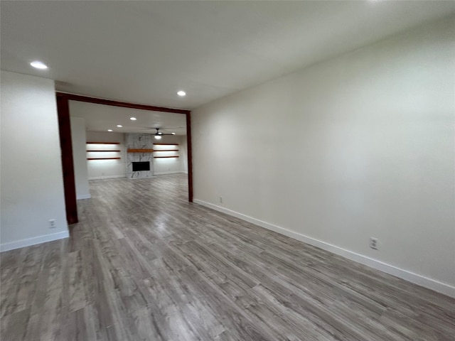 spare room with a fireplace and hardwood / wood-style floors