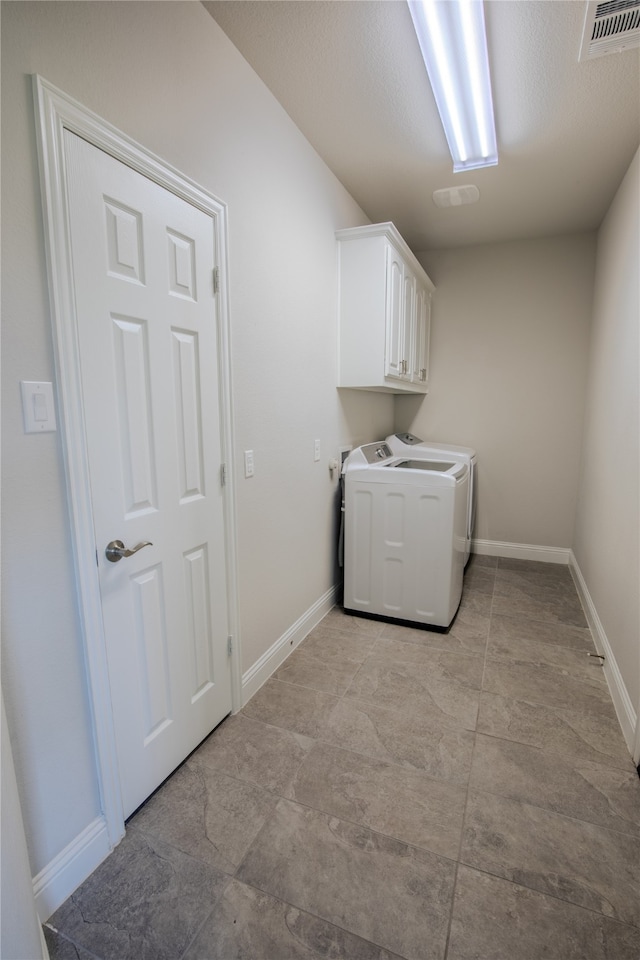 laundry room with washer and dryer and cabinets