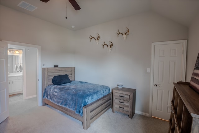 carpeted bedroom with vaulted ceiling, ceiling fan, and ensuite bathroom