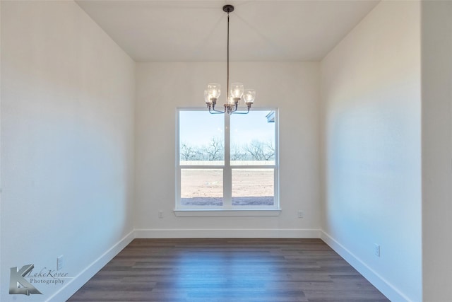 unfurnished dining area with baseboards, dark wood-type flooring, and an inviting chandelier