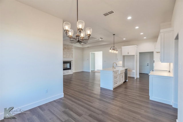 kitchen featuring visible vents, white cabinets, dishwasher, open floor plan, and a kitchen island with sink