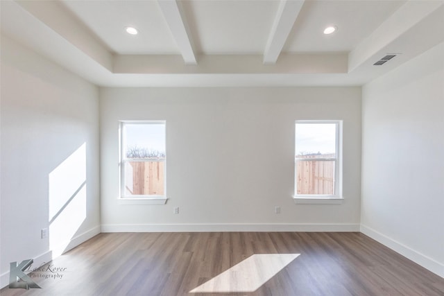 unfurnished room featuring a healthy amount of sunlight, baseboards, and beamed ceiling