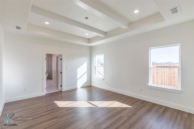 empty room featuring baseboards, visible vents, dark wood finished floors, and beam ceiling