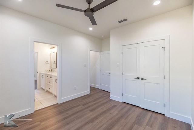 unfurnished bedroom with light wood finished floors, a closet, and recessed lighting