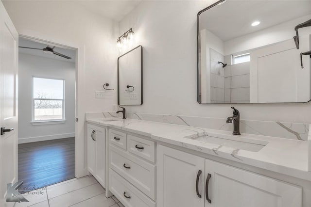 full bathroom with a sink, baseboards, and double vanity