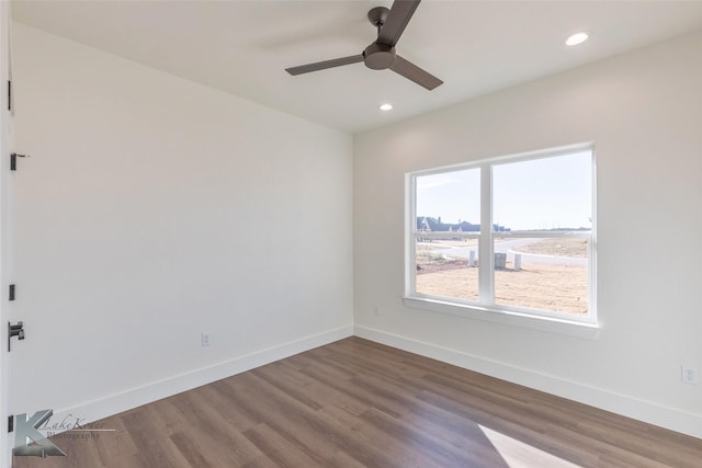 empty room featuring baseboards, recessed lighting, and wood finished floors