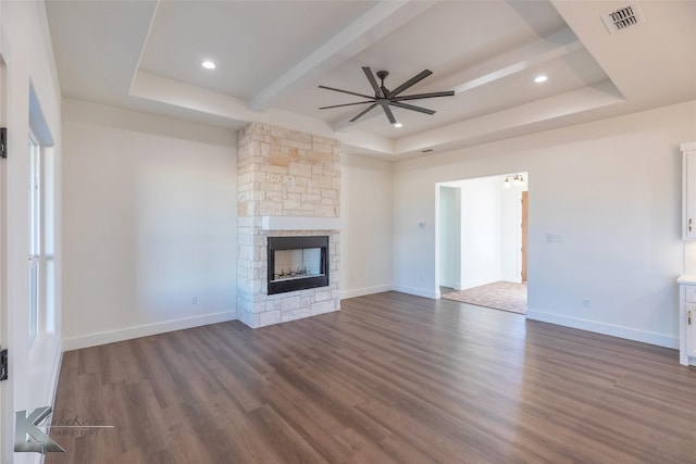 unfurnished living room featuring a fireplace, dark wood-style floors, a raised ceiling, and baseboards