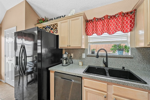 kitchen with lofted ceiling, sink, black refrigerator with ice dispenser, and stainless steel dishwasher