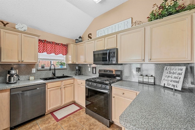 kitchen with appliances with stainless steel finishes, decorative backsplash, a textured ceiling, lofted ceiling, and sink