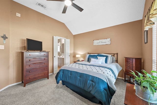 bedroom featuring ceiling fan, vaulted ceiling, light colored carpet, and ensuite bathroom