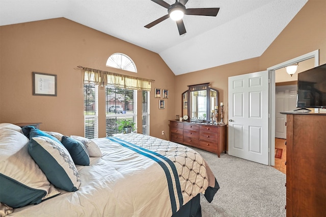 bedroom with ceiling fan, light colored carpet, and vaulted ceiling