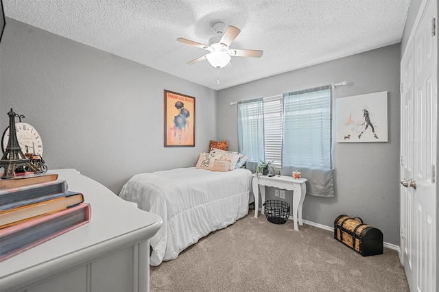 carpeted bedroom featuring ceiling fan and a textured ceiling