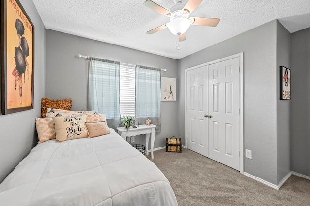 bedroom featuring a textured ceiling, carpet flooring, ceiling fan, and a closet