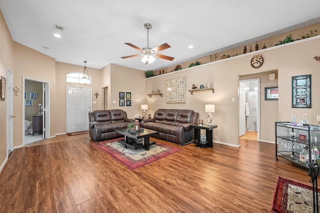 living room with ceiling fan, a textured ceiling, and hardwood / wood-style floors