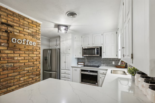 kitchen featuring tasteful backsplash, stainless steel appliances, crown molding, sink, and white cabinetry