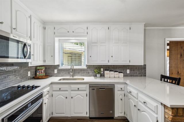 kitchen with sink, decorative backsplash, white cabinetry, kitchen peninsula, and stainless steel appliances