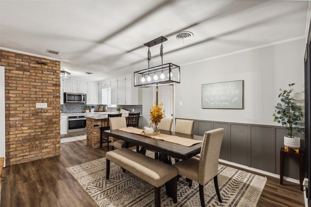 dining room with dark wood-type flooring and ornamental molding