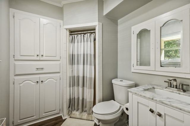 bathroom featuring hardwood / wood-style floors, vanity, crown molding, a shower with shower curtain, and toilet