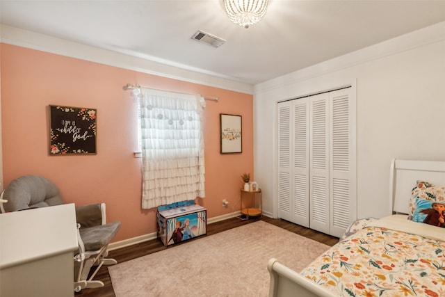 bedroom featuring hardwood / wood-style floors, a closet, and ornamental molding