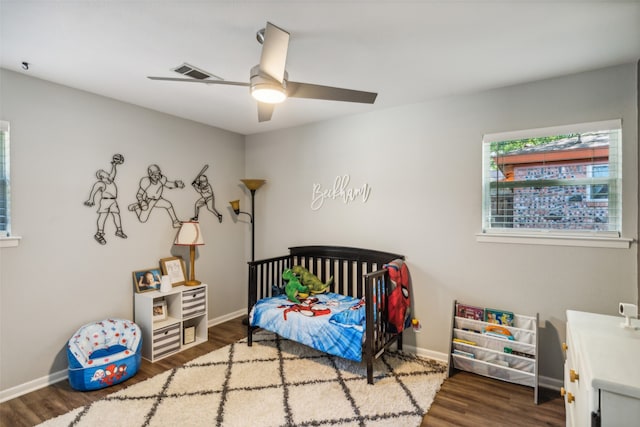 bedroom with dark hardwood / wood-style flooring and ceiling fan